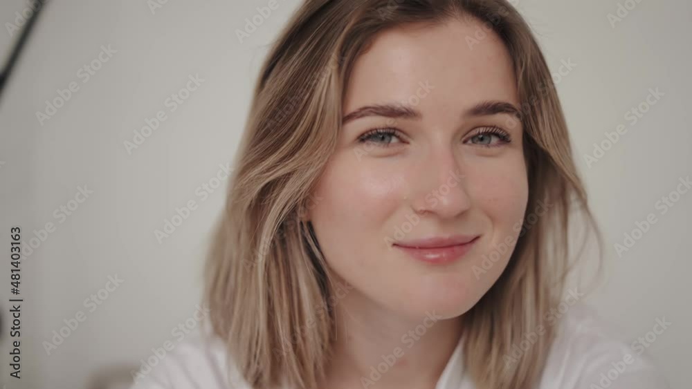 Smiling young woman looking to camera sitting on the bed Smiling young woman looking to camera sitting on the bed