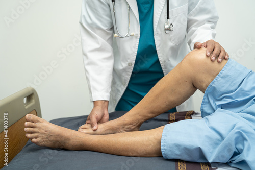 Asian doctor physiotherapist examining, massaging and treatment knee and leg of senior patient in orthopedist medical clinic nurse hospital. © amazing studio
