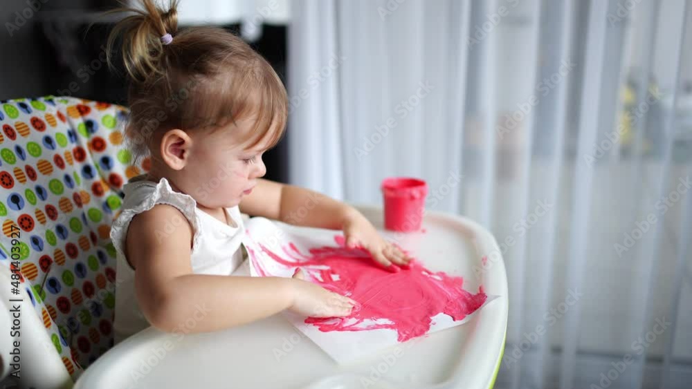 Cute little girl painting with fingers at home. Creative games for kids. Stay at home entertainment Cute little girl painting with fingers at home. Creative games for kids. Stay at home entertainment