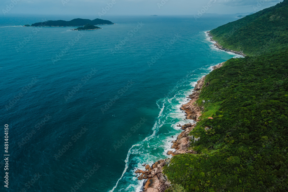 Scenic coastline with islands in blue ocean with waves in Brazil, Saquinho beach.