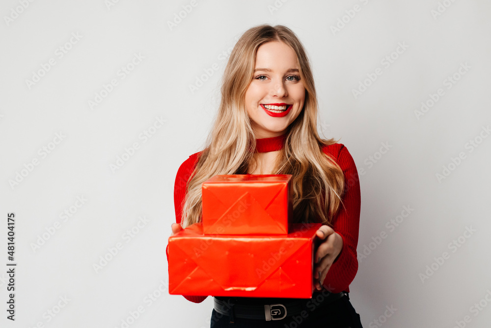 International women's and mother's day. Daughter with two red gift boxes is ready to congratulate her mom. Family holidays at home concept International women's and mother's day. Daughter with two red gift boxes is ready to congratulate her mom. Family holidays at home concept
