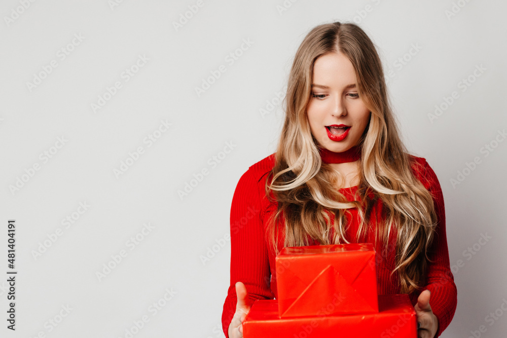Surprised young blonde woman got impressive gifts from her friends. Woman celebrating birthday. Friendship concept Surprised young blonde woman got impressive gifts from her friends. Woman celebrating birthday. Friendship concept