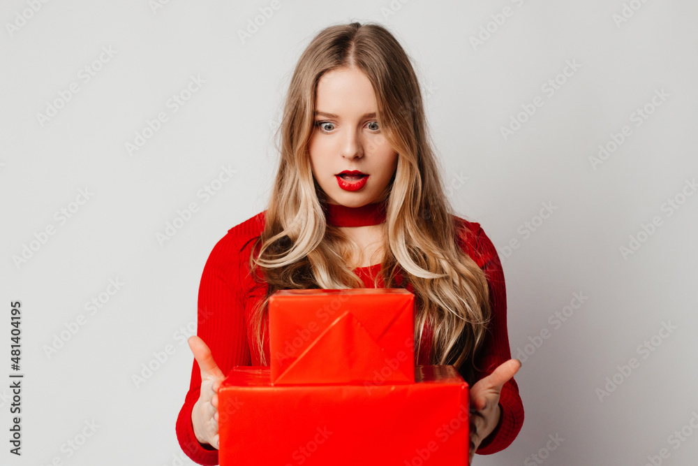 Surprised young blonde woman got impressive gifts from her friends. Woman celebrating birthday. Friendship concept Surprised young blonde woman got impressive gifts from her friends. Woman celebrating birthday. Friendship concept