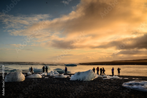 Fényképezés Silhouette of tourists enjoying the sunset amidst the remains of melted icebergs