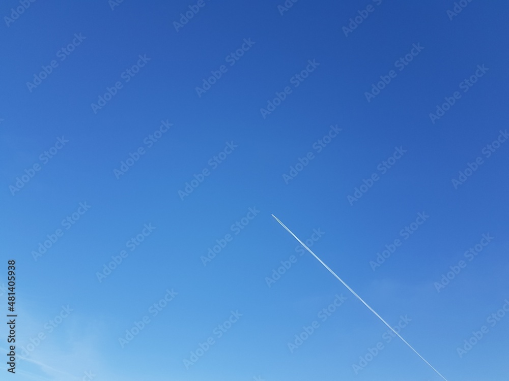 White trace from the plane in the blue sky White trace from the plane in the blue sky