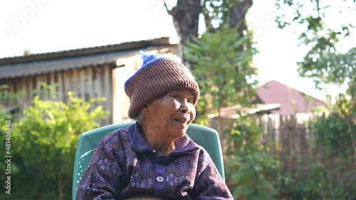 Asian elderly native woman smiling with happy in countryside in nature background in slow motion. Senior female have relaxing moment in morning. Concept of people rural lifestyle, northern Thailand. 