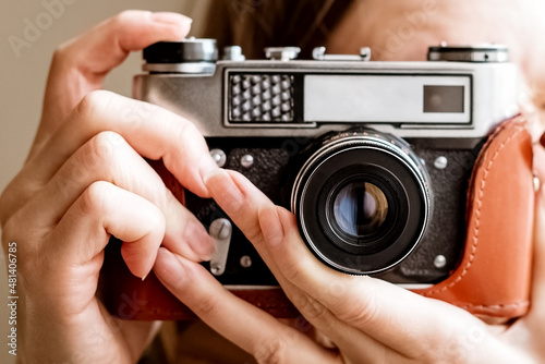 Fotografia Woman make picture on old vintage film slr photo camera in leather cover