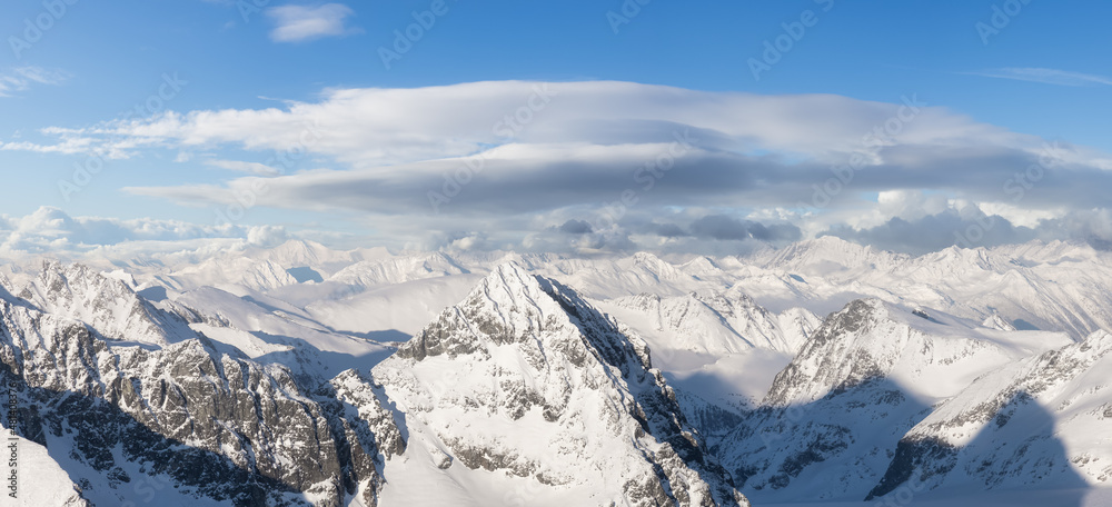 Aerial Panoramic View of Canadian Mountain covered in snow. Sunny winter season with cloudy sky art render. Located near Whistler, North of Vancouver, British Columbia, Canada. Nature Background