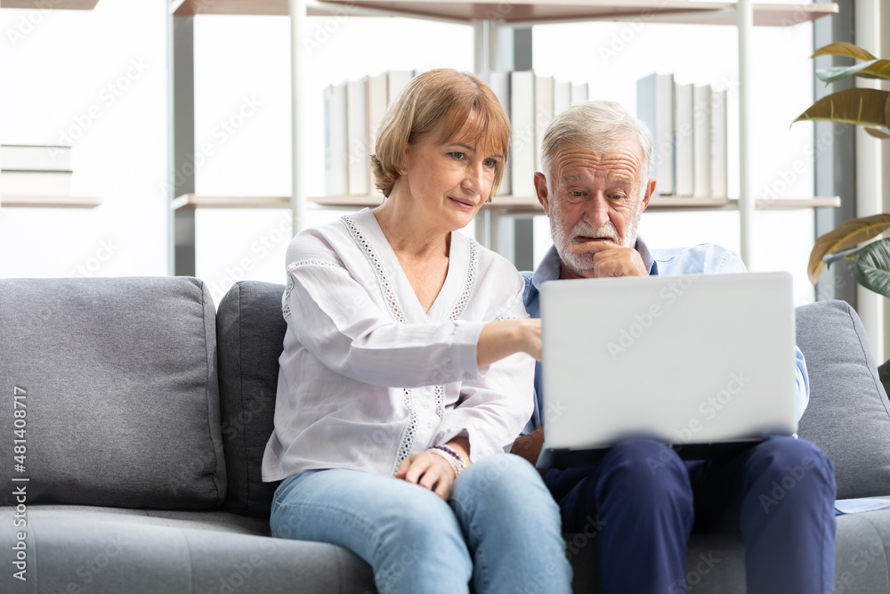 © offsuperphoto - senior couple using laptop computer on sofa