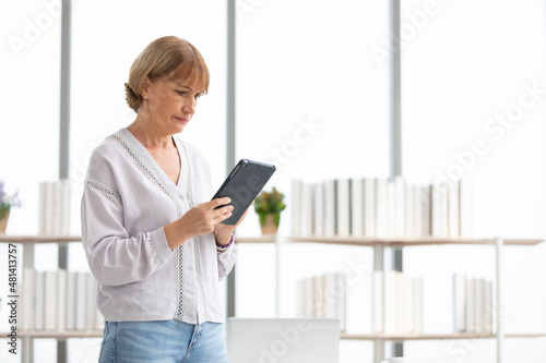 senior woman using tablet computer for work in office