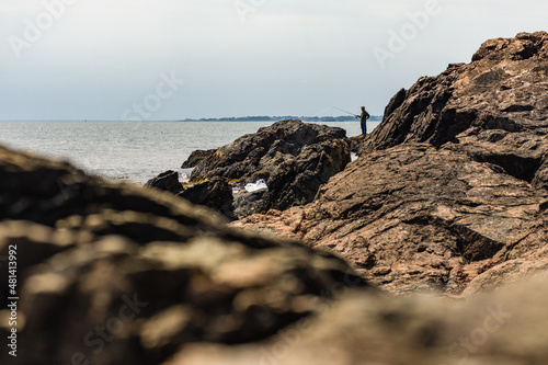 Fisherman on rocky shore, Rhode Island