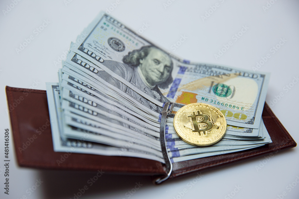 Gold bitkoyny and hundred-dollar bills in a leather purse. Bitcoin with a dollar in his wallet. fall of bitcoin Gold bitkoyny and hundred-dollar bills in a leather purse. Bitcoin with a dollar in his wallet. fall of bitcoin