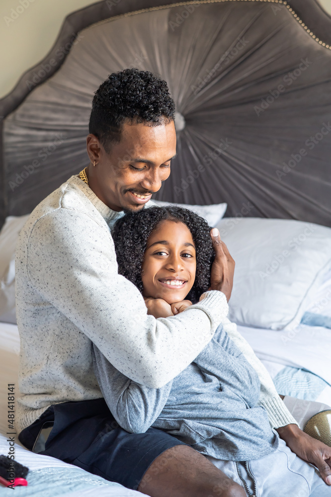 Father with prosthetic leg embracing son in bedroom Father with prosthetic leg embracing son in bedroom