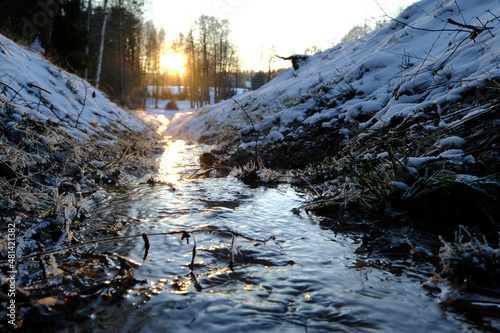 Photographie brook in the winter at sunset with snow