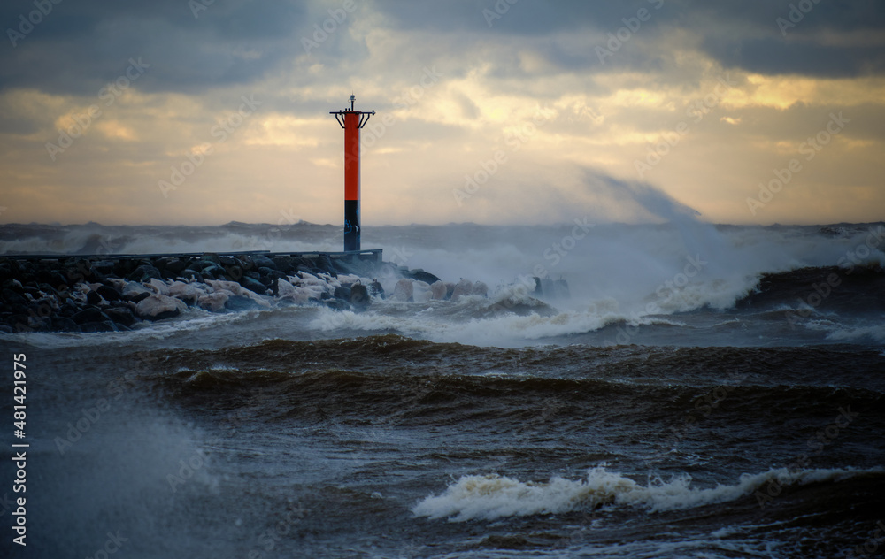 lighthouse on a windy storm on a baltic sea at winter with clouds in the sky - obrazy, fototapety, plakaty 