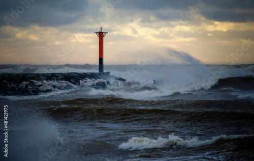 lighthouse on a windy storm on a baltic sea at winter with clouds in the sky