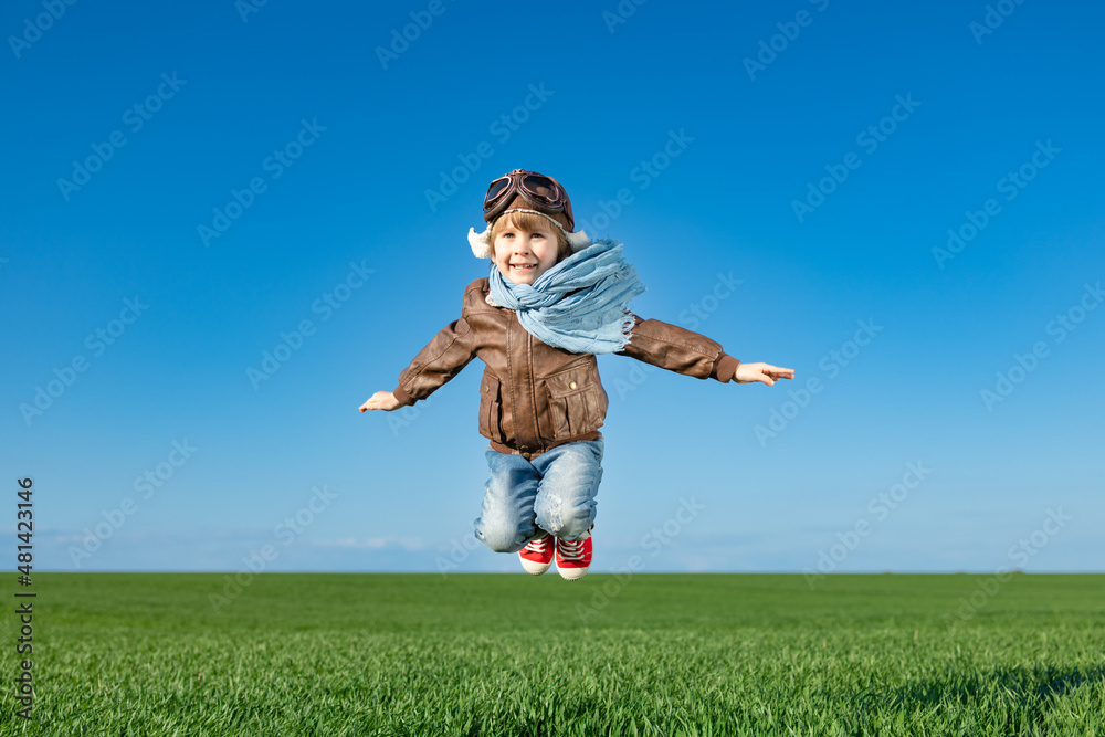 Happy child jumping outdoor in spring field Happy child jumping outdoor in spring field