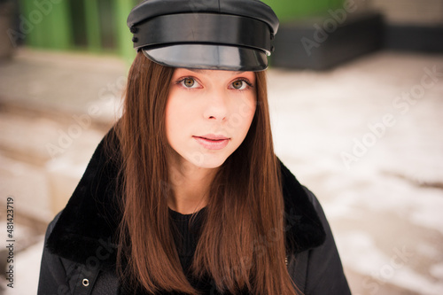 Closeup portrait of young model wears black fashion cap and black jacket posing winter outdoor in the city © alipko
