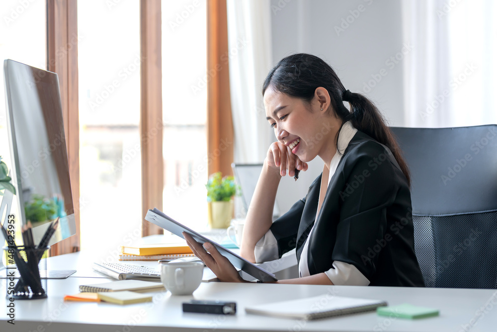 Confident young Asian businesswoman sitting working at her workplace at modern office. Confident young Asian businesswoman sitting working at her workplace at modern office.