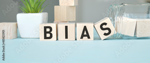 Bias - word from wooden blocks with letters, personal opinions prejudice bias concept, random letters around photo