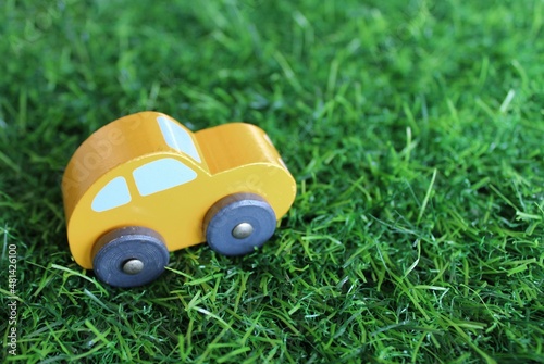 Selective focus image of toy car on green grass with copy space