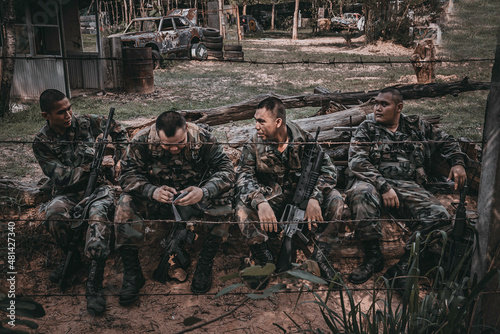 Photography Team of army soldier with machine gun moving in the forest,Thai militia soldier in combat uniforms in the wood,Wander the patrol sloping in the rainforest