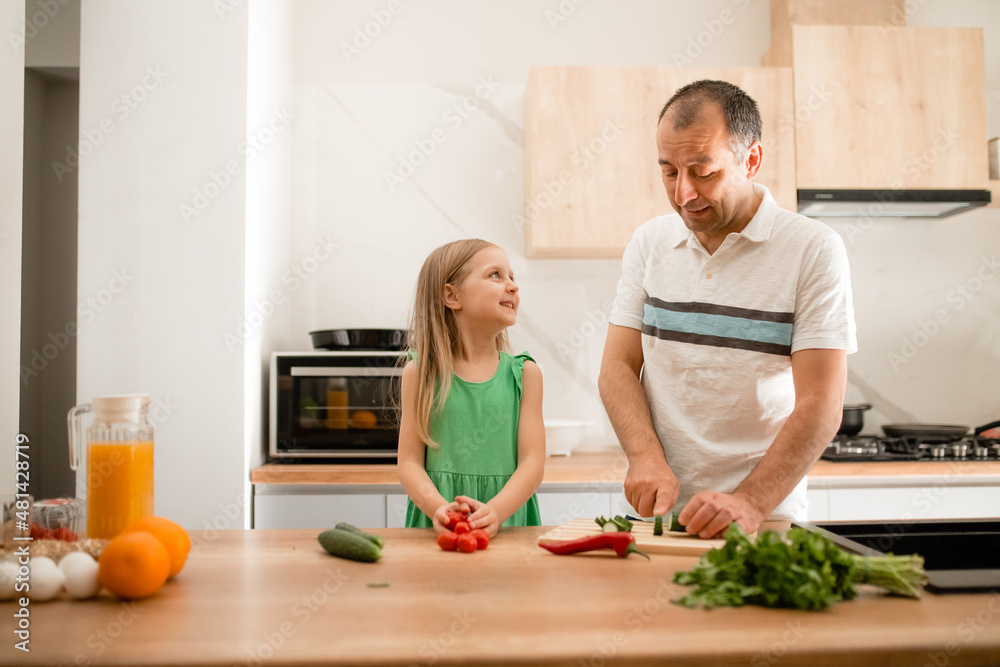 Father and daughter preparing breakfast in the kitchen. Father and daughter preparing breakfast in the kitchen.