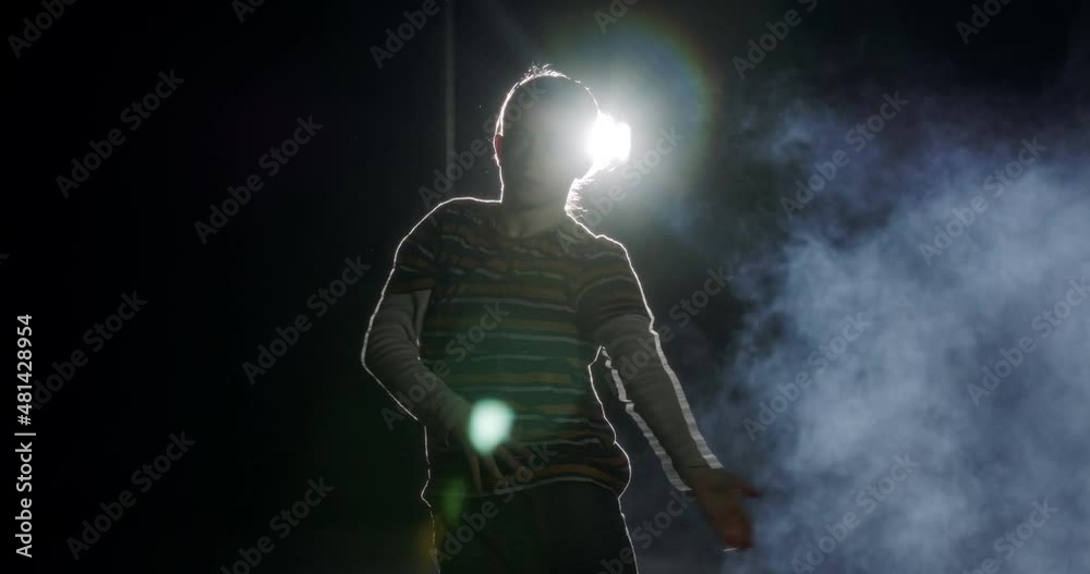 silhouette of a female dancer performing hip hop dance with light and smoke background silhouette of a female dancer performing hip hop dance with light and smoke background