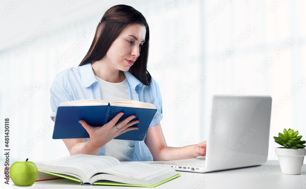 Exhausted lady sitting at the table, writing in a notebook, studying Exhausted lady sitting at the table, writing in a notebook, studying
