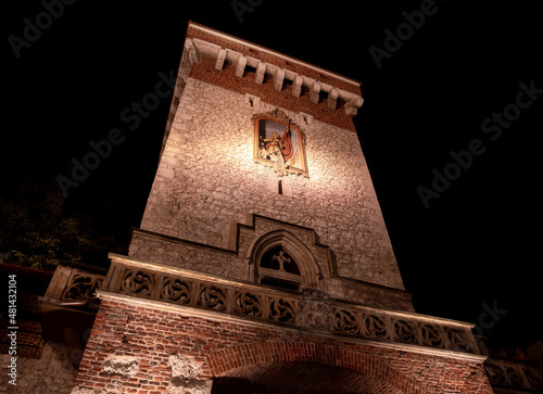 St. Florian's Gate or Florian Gate (Brama Floriańska Kraków) by night. Gothic tower, part of historic fortifications in the Old Town of Krakow, Poland.