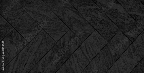 luxury black herring bone patterned stone floor in close up view. dark black concrete or cement flooring pattern for walkway, sidewalk. pavement texture background in dark color tone.