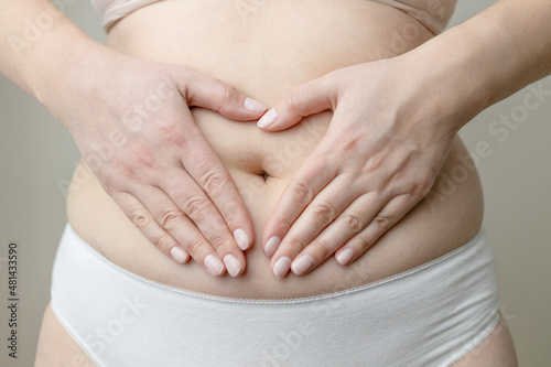 Wallpaper Mural Closeup cropped of unrecognizable plus size woman in underwear holding hands on abdominal area forming heart shape around navel Torontodigital.ca