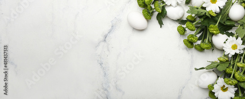 Composition with Easter eggs and spring flowers on light background with space for text