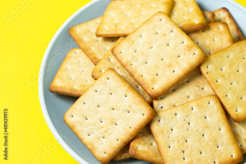 Crackers on a yellow background. Fresh crispy crackers on a plate.