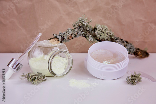 Face care cosmetics and massager. Wellbeing serum, alginate mask and patches: multitasking beauty products. Scinimalism concept, polytasking functions. Natural eco forest moss. Dermatology cosmetics. photo