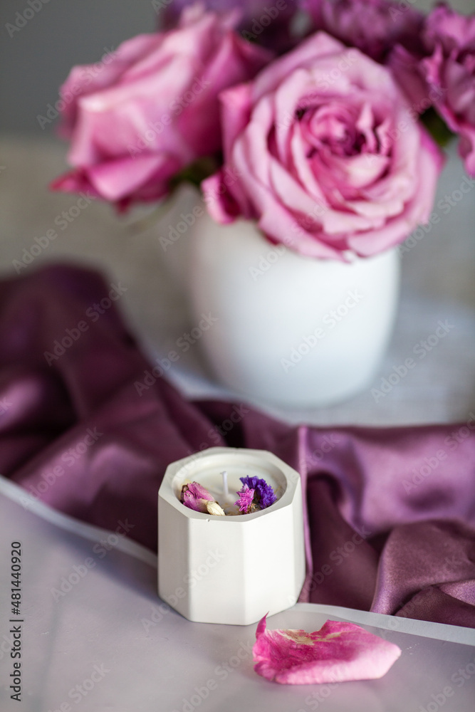 a candle in a white pot on a purple fabric, handmade a candle in a white pot on a purple fabric, handmade