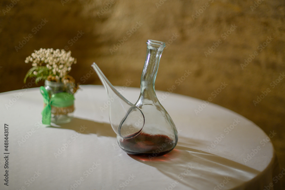Decanter with red wine on a table . Wine drinking vessel typical of Spain ( Porron ).