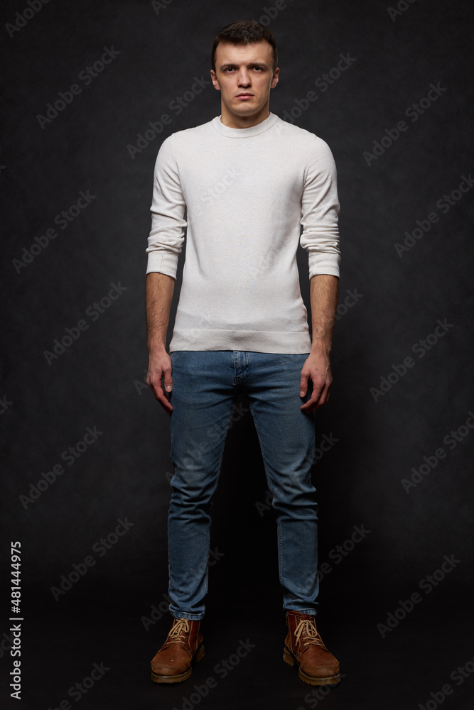Full length portrait of a young man in the studio on a black background. Full face. Full length portrait of a young man in the studio on a black background. Full face.