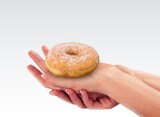 Hand holds Hanukkah donut with jam on the background.