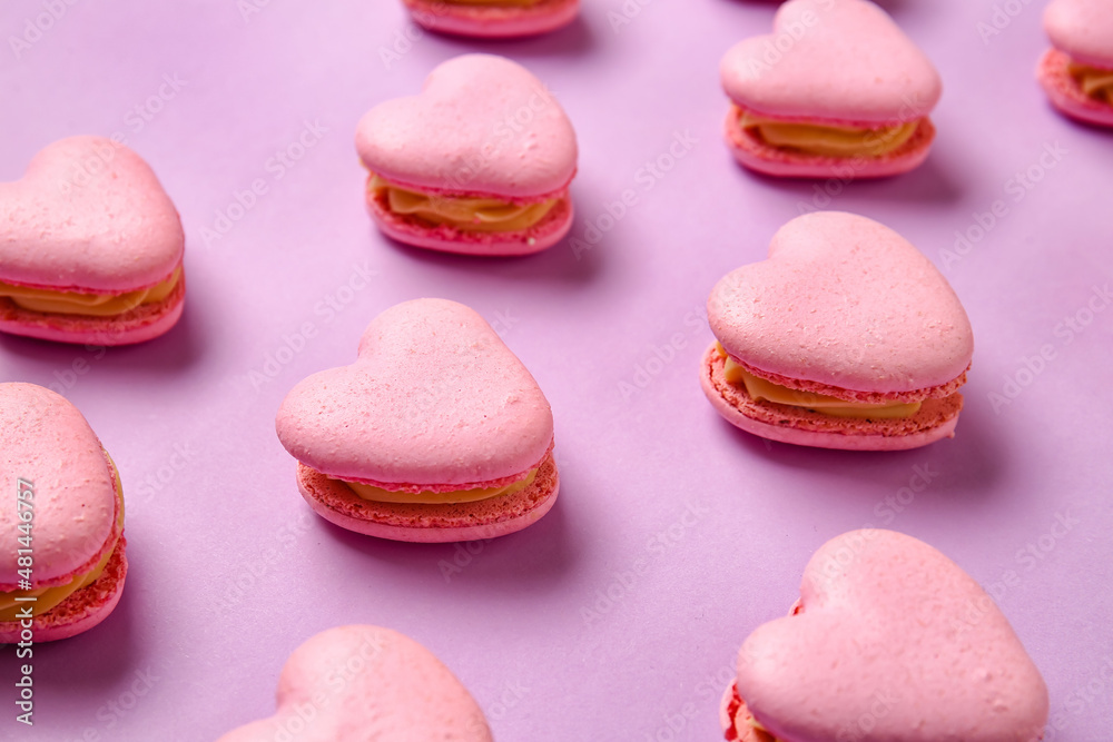 Tasty heart-shaped macaroons on purple background, closeup Tasty heart-shaped macaroons on purple background, closeup