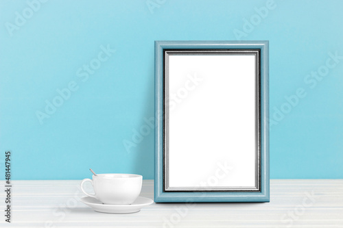 Poster template. Photo frame on wooden table with coffee cup