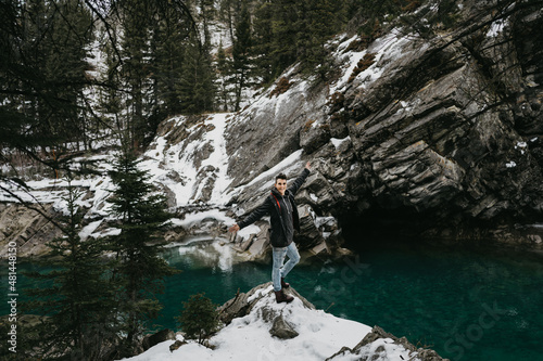 Standing on a cliff overlooking a clear river in the mountains 