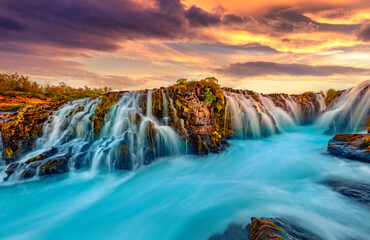 Wonderful summer view of Bruarfoss Waterfall, secluded spot with cascading blue waters. Great sunset in Iceland, Europe. Beauty of nature concept background.