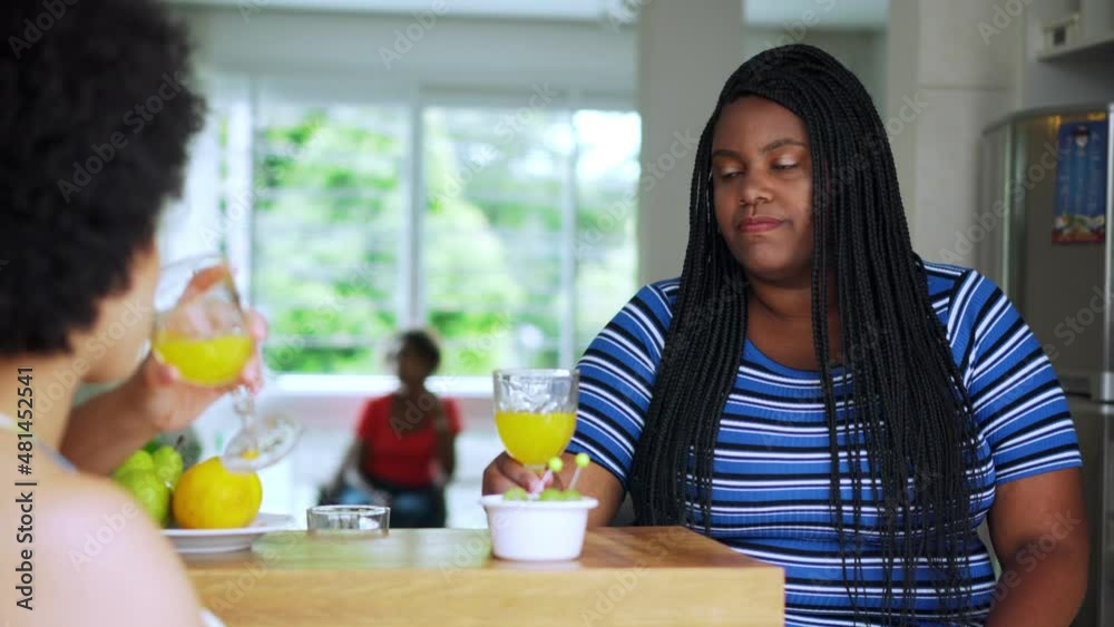 Black woman welcomes friend to toast with healthy drink in small afternoon meeting. Female friends drinking and eating heathy food
Black woman welcomes friend to toast with healthy drink in small afternoon meeting. Female friends drinking and eating heathy food