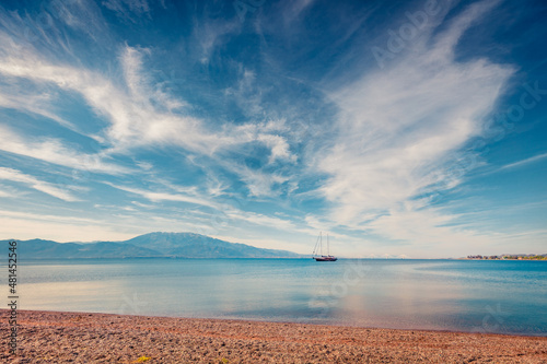 Fototapeta Naklejka Na Ścianę i Meble -  Beautiful spring view of Nafpaktos public beach with yacht on background. Sunny morning scene of the Gulf of Corinth, Greece, Europe. Traveling concept background.