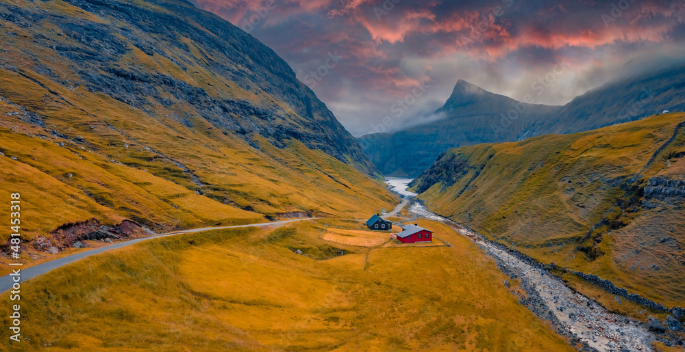 Fantastic autumn view from flying droneof Saksun village. Splendid evening scene of Pollurin canyon, Faroe Islands, Denmark, Europe. Traveling concept background.