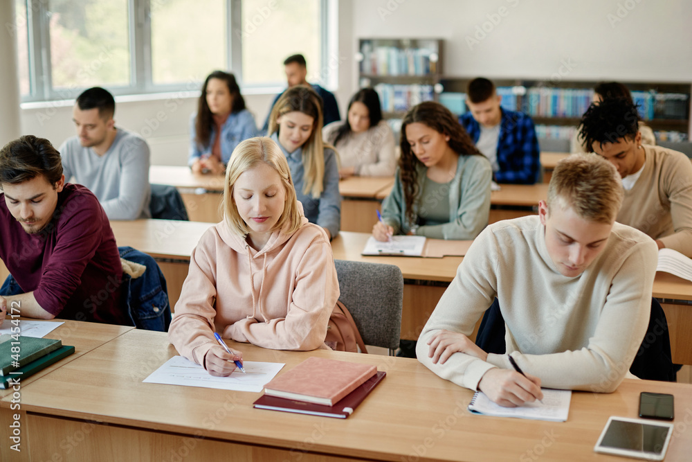 Large group of students writing an exam during class at the university. Large group of students writing an exam during class at the university.