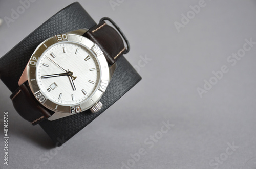 Wrist men's watch made of metal on a gray background.
