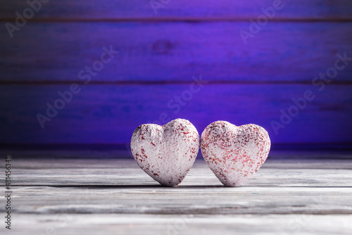 Two hearts over wooden background with blue backlight. Valentines day greeting concept