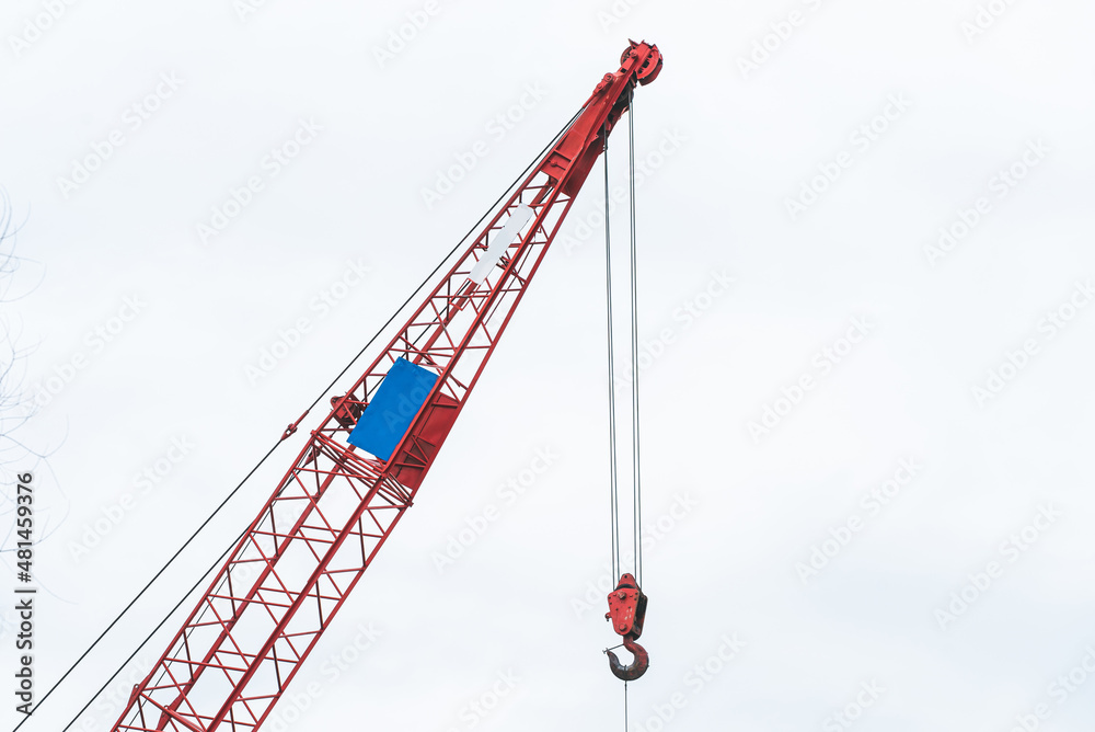 Workers cut an old steel bridge with a large crane on the water